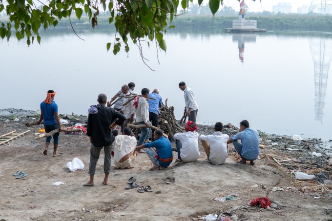 Một nhóm người chuẩn bị hỏa táng người chết bên sông Hằng.