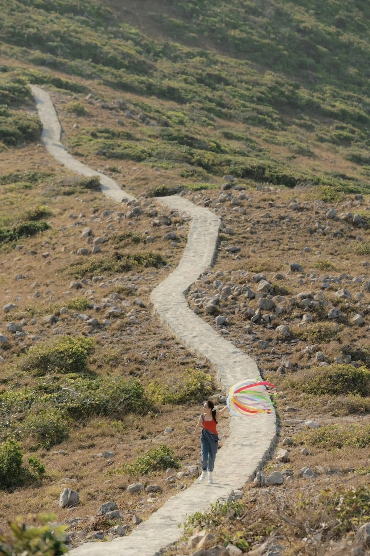 Điểm nhấn được nhiều người yêu thích là mỏm đá nhô ra vươn dài như “sống lưng khủng long”, nơi lý tưởng để ngắm toàn cảnh Côn Đảo từ trên cao. Từ vị trí này, vịnh Côn Sơn xanh biếc, những dãy núi bao quanh và thị trấn nhỏ nhắn hiện ra rõ mồn một dưới tầm mắt. Ảnh Nhi Ng