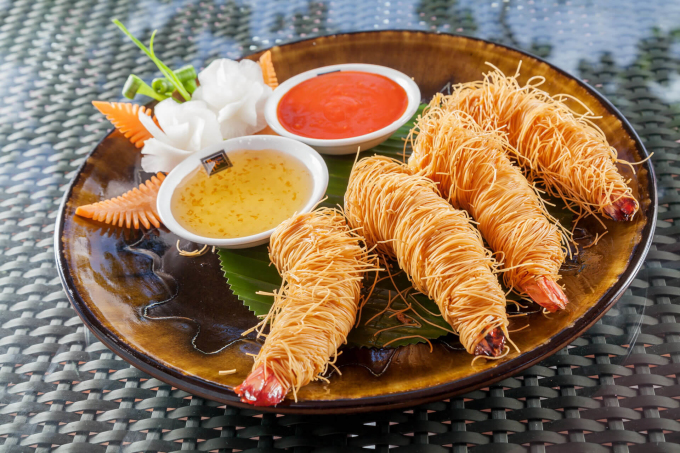 Món tôm bọc chiên xù theo phong cách Phuket với lớp vỏ giòn rụm, thịt tôm ngọt chắc, chấm với nước mắm chua ngọt. Cả Ngọc Trinh và Diệu Nhi đều hết lời khen các món trong thực đơn. Cô bé ăn hàng cho biết quán đẹp và đồ ăn ngon xuất sắc.