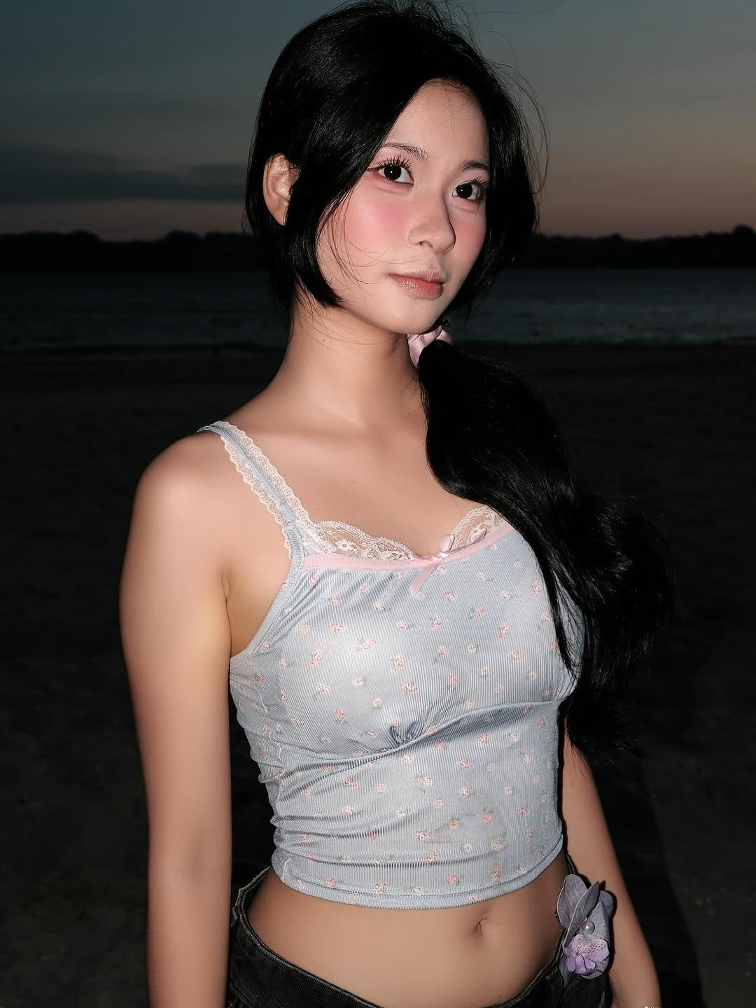 Cô diện áo hai dây xanh nhạt với họa tiết hoa nhỏ xinh, kết hợp cùng quần short jeans đen đơn giản. (Ảnh: FBNV)