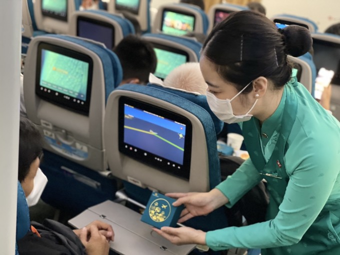 Tiếp viên Vietnam Airlines phục vụ bánh trung thu trong một chuyến bay dịp lễ Vu Lan. Ảnh: